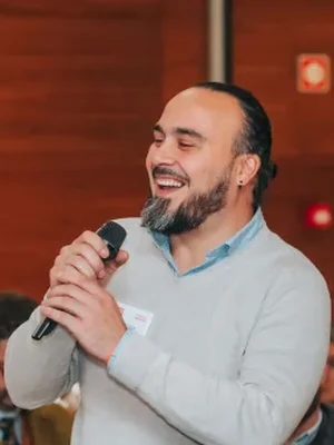 Raúl Duque hablando con un micrófono en una sala llena